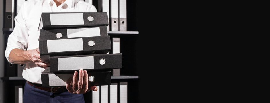Business banner. Office worker holding many accounting documents, folders binders stack in hand with copy space for text. High quality photo