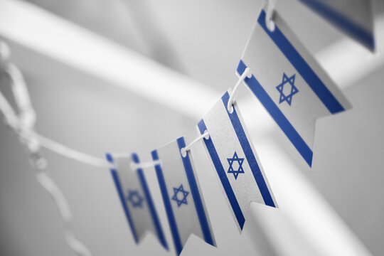 A garland of Israel national flags on an abstract blurred background