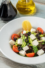 Mediterranean salad with olives and cheese on a white porcelain plate