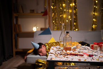 Drunk man sleeping on sofa after party at home