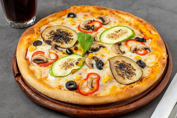 Vegetarian pizza with eggplant, zucchini and mushrooms on dark stone table