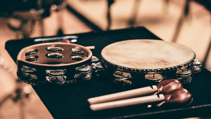 Indoor concert background abstract percussion music instruments tambourine and castanet with handle...