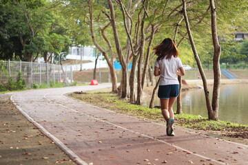 Woman runner running through the park. Young girl running.