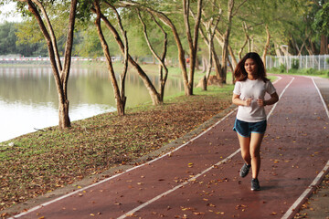 Woman runner running through the park. Young girl running.