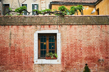 Red brick facade with white window in Venice, Italy, Veneto