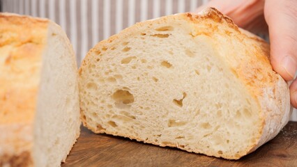 Male heads squeezing fresh bread loaf. Check bread freshness