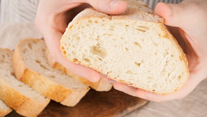 Male heads squeezing fresh bread loaf. Check bread freshness