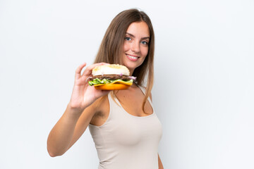 Young pretty woman holding a burger isolated on white background with happy expression