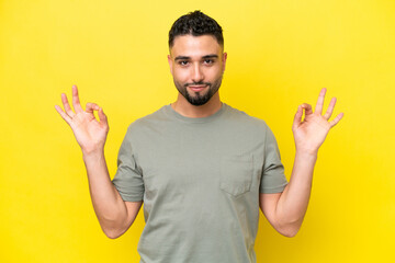 Young Arab handsome man isolated on yellow background in zen pose