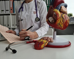 Cardiologist doctor holds electrocardiogram of heart and patient