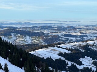 Winter panorama from the top of the Kronberg mountain with a view of the Swiss hills and pastures covered with the first snow, Urnäsch (Urnaesch or Urnasch) - Canton of Appenzell, Switzerland (Schweiz