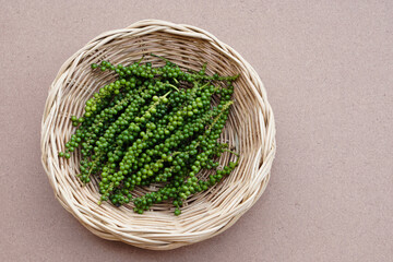  Fresh green young Thai pepper fruits in basket, isolated on brown background.Concept, herbal...