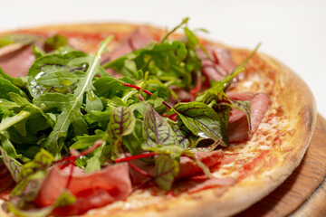 pizza with ham and basil on desk on white background
