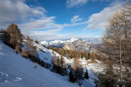 image panoramique avec une vue magnifique sur les montagnes enneigées des Alpes. le soleil éclaire le sommet des montagnes avec un beau ciel bleu et quelques nuages.