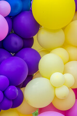 Fototapeta na wymiar Bright abstract background of jumble of rainbow colored balloons, celebrating