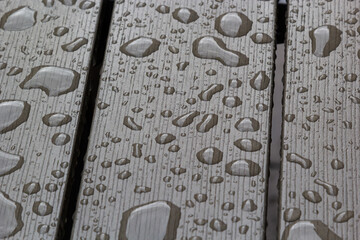wet wooden planks of bench, background of wood texture with water drops from the rain, autumn mood