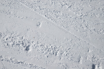 gros plan sur un sol enneigé, sur une piste de ski en plein hiver, pouvant servir d'arrière plan ou de fond texturé.