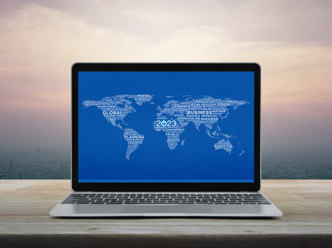 Start up 2023 business icon with global words world map with laptop computer on table over city at sunset, vintage style, Happy new year 2023 start up online, Elements of this image furnished by NASA