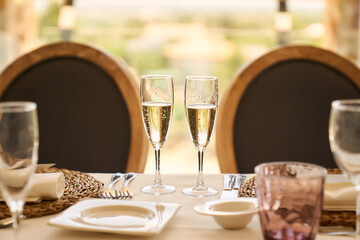 two glasses of champagne against the light at the table ready to eat