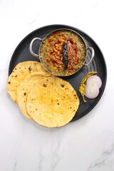 Sarson ka saag and Makke di roti. mustard leaves curry. It's a popular Punjabi winter dish made using corn meal and mustard leaves. served with onions and green chili. with copy space.