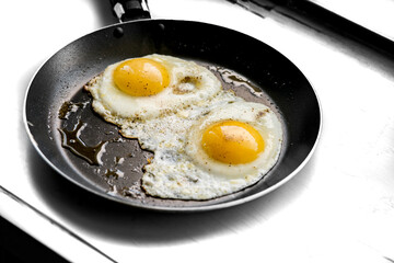 close-up shot of fried eggs on black pan