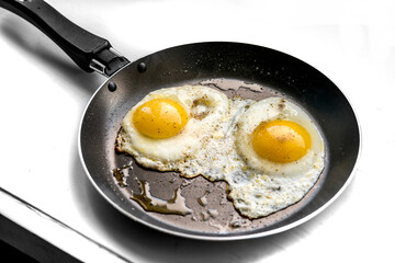 close-up shot of fried eggs on black pan