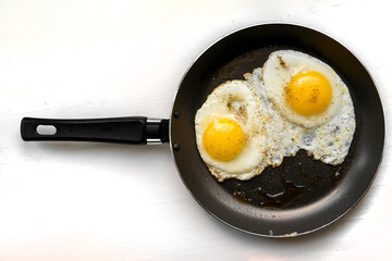 close-up shot of fried eggs on black pan