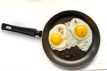close-up shot of fried eggs on black pan