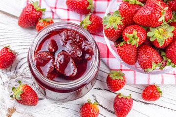 Homemade delicious strawberry jam and strawberry on a rustic wooden table