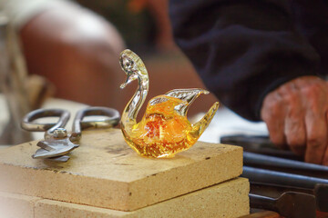 Final work in the manufacturing and modeling process of a glass figure, Murano, Venice, Italy
