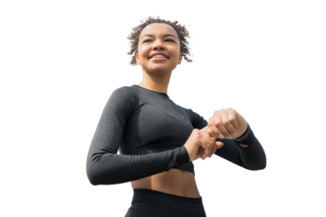 A young adult woman running in sportswear uses a fitness watch, isolated transparent background.