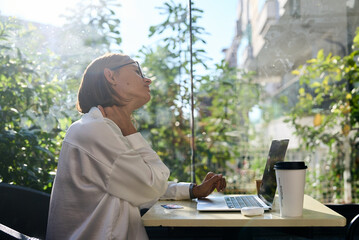 Tired stressed woman suffering from neckpain working from home office sitting at table. Overworked young aged lady massaging neck feeling hurt pain from incorrect posture.