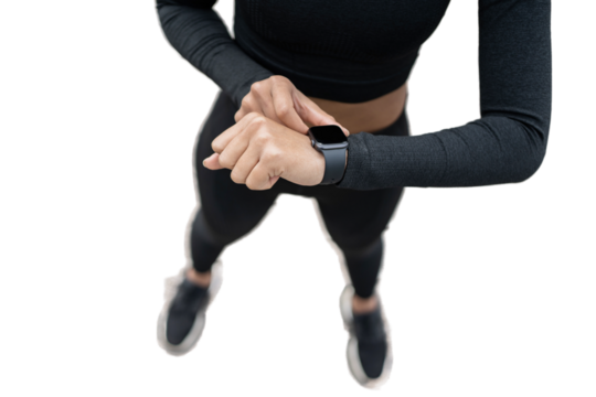 A young adult woman running in sportswear uses a fitness watch, isolated transparent background.