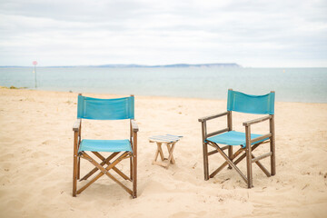 Fototapeta na wymiar Chairs on a beach. Dorset coast with view of Isle of Wight, UK