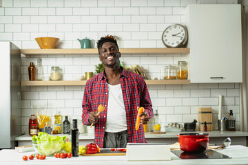 Attractive man cooking in modern kitchen. Handsome chef preparing food.