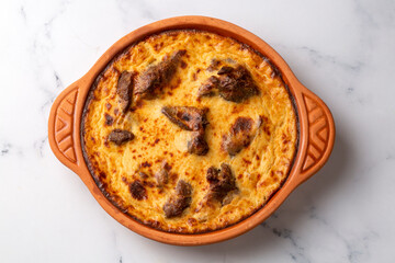 Tave kosi is a national Albanian dish of baked lamb and rice with yoghurt close-up in a pan on the table. horizontal top view from above. Turkish name; Elbasan tava