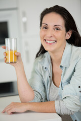 woman holding a glass of orange juice