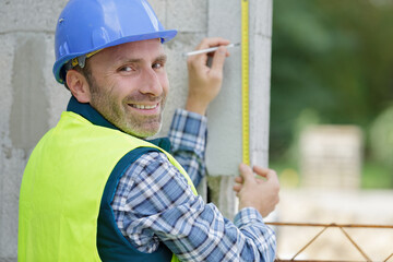 portrait of a happy craftsman erecting a wall