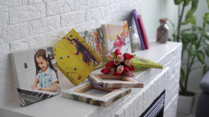 Naklejka na ściany i meble photo canvases of active little girl and flowers tulips as a holiday gift lie on the shelf