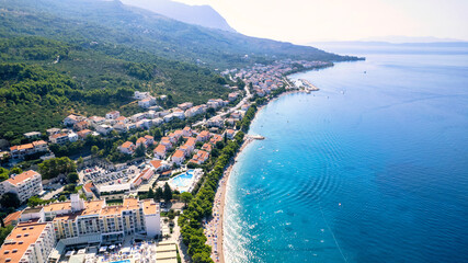 Panorama of Baska Voda town with harbor against mountains in Makarska riviera, Dalmatia, Croatia