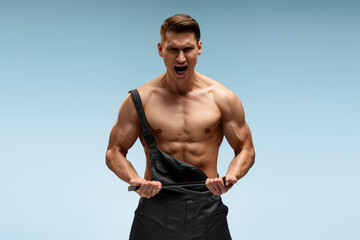 Screaming caucasian man in coverall posing over blue background