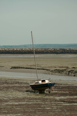A boat on low tide on a beach