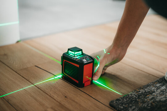 Builder and handyman using laser leveler to measure and draw lines and check interior