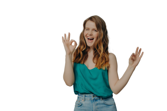 Charming funny girl shows OK sign with hands, winking and looking at camera with big smile