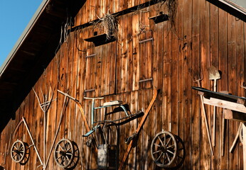 Vintage Austrian wooden tools on an antique barn wall - retro ski, wheels, garden tools.