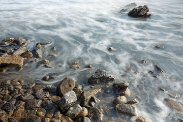 Blurred waves crashing on the stones of the beach of Guaruja city, Sao Paulo state, Brazil