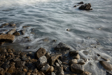 Blurred waves crashing on the stones of the beach of Guaruja city, Sao Paulo state, Brazil