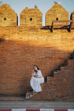 tourist girl on the stairs of the historic city gate Pratu Tha Phae of chiang mai, thailand.