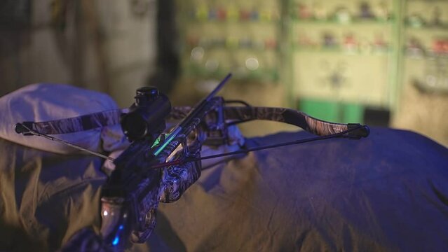 on the table lies a crossbow with a collimator sight with an arrow. High-quality Full HD video recording. live video