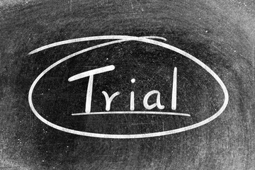 White chalk hand writing in word trial and circle shape on blackboard background